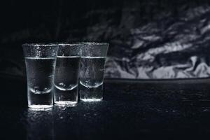 Vodka. Shots, glasses with vodka with ice .Dark background. Copy space .Selective focus. photo