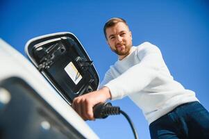 Young man charging his car photo