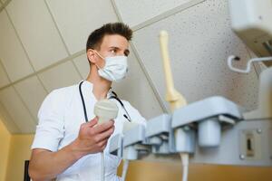 Male doctor in mask with ultrasound equipment in the clinic office photo