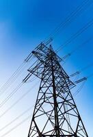 Dark silhouette of electric wire construction. Energy technologies tower shadows. photo