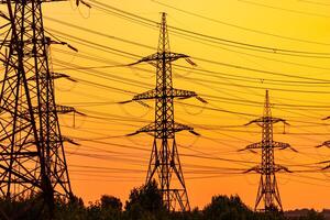 Electricity energy line towers. Huge silhouette of electric supply. photo