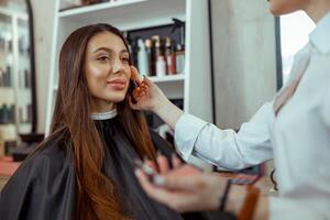 Young female customer getting blush powder on her cheek with a brush photo