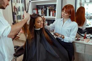 Beauty salon workers decorate female customer and prepare her for event photo