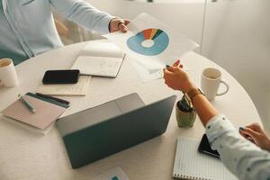 Close up of business colleagues analysts working with documents together sitting in office photo
