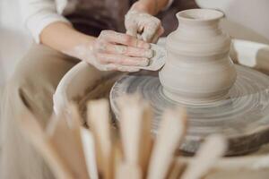 Close up of artisan's hands shaping clay bowl in pottery studio. Pottery art and creativity photo