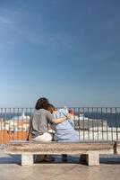 Back view of couple hugging while sitting on old city view with ancient architecture background photo