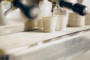 Coffee machine filling a two cups with espresso in professional coffee shop photo