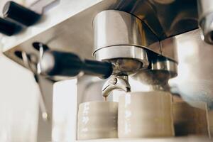 Close up of coffee machine filling a two cups with espresso in professional coffee shop photo