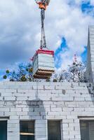 Construction crane with blocks in front of blue sky. Building high residential buildings. photo