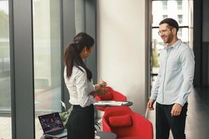 HR manager invites a candidate for a vacancy to sit down for an interview photo