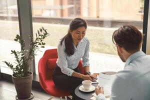 Two business colleagues analysts working with documents together sitting in office. Teamwork concept photo