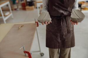 Close up of ceramist woman wearing apron is preparing clay to make pottery pieces in her studio photo