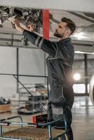 Male aviation mechanic repairing aircraft at repair station photo