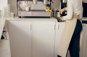 Close-up of barista making coffee with manual presses using tamper at the coffee shop photo