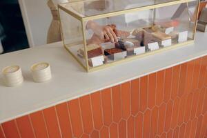 Close-up of female waitress hands putting a delicious dessert on a plate standing behind bar counter photo