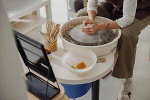 Close up of artisan's hands shaping clay bowl in pottery studio. Pottery art and creativity photo