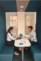 Two business colleagues working together with financial statements in stylish coworking photo