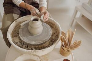 Close up of artisan's hands shaping clay bowl in pottery studio. Pottery art and creativity photo