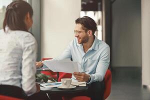 Two business colleagues analysts working with documents together sitting in office. Teamwork concept photo