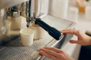 Barista use coffee machine for filling a two cups with espresso in professional coffee shop photo