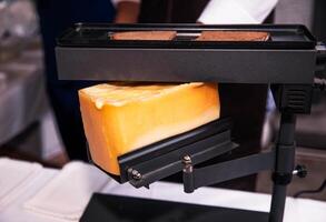 Melting Raclette Cheese on a Modern Electric Griller at a Food Event photo