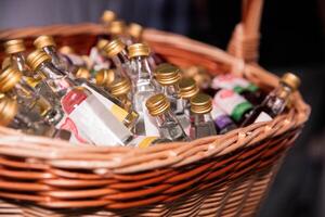 Assorted Miniature Bottles of Liquor in a Woven Basket at a Bar photo