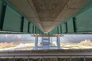 steel frame and concrete construction huge car bridge across the wide river photo