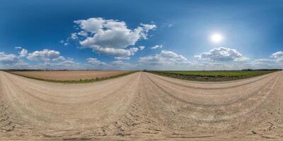 360 hdri panorama on gravel road with marks from car or tractor tires with clouds on blue sky in equirectangular spherical  seamless projection, skydome replacement in drone panoramas photo