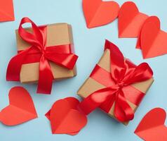 Gift box with red satin ribbon and bow on a blue background.Holiday background photo