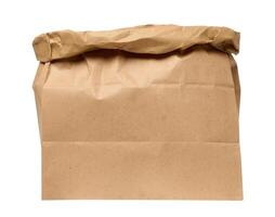 A large empty brown kraft paper bag for packaging products in stores on an isolated background photo