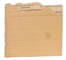 Piece of brown cardboard with torn edges on isolated background photo