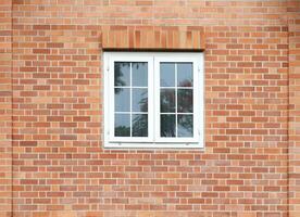 Classic white windows on brick wall facade. photo