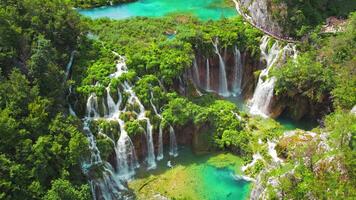 montaña paisaje con corrientes de agua y cascadas personas excursionismo en estrecho camino en plitvice lagos nacional parque Croacia. video