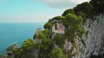 Frau mit Blick auf das Tyrrhenisch Meer von Capri Insel. weiblich meditiert auf felsig Kante im Sommer- sonnig Tag. Mädchen beobachtet Natur im Italien. video