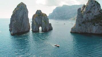 corsaire île avec iconique mer piles faraglioni monter de le tyrrhénien mer. loisir yachts et bateaux dans le idyllique italien des eaux. video