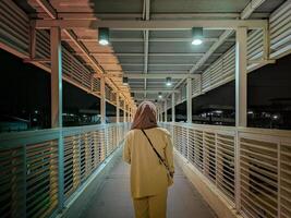 Hijab woman walking in hospital tunnel photo