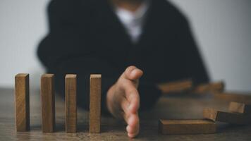 Hand-stopping domino effect. Concept of risk protection, business solution, or successful intervention strategy. photo