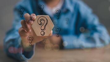 Businessmen holding Questions Mark on the wooden block. FAQ frequently asked questions, Answer, Q and A, Information, Communication and interrogation Concepts photo