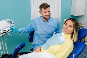 un hermosa niña paciente es sentado en el del dentista oficina a el recepción y siguiente a el médico foto