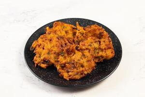 Indian spicy vegetable pakora or pakoda served in dish isolated on table top view photo