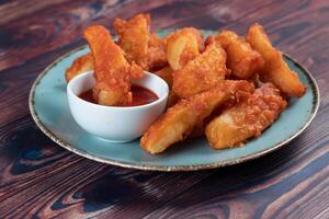 Potatos wedges with tomato sauce served in dish isolated on background side view of fastfood photo