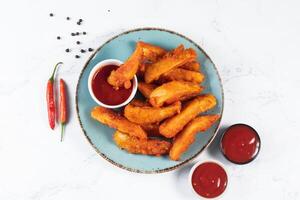 Potatos wedges with tomato sauce served in dish isolated on background side view of fastfood photo