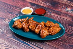 crispy chicken wings with ketchup and mayo dip served in dish isolated on background top view photo