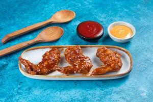 crispy chicken wings with ketchup and mayo dip served in dish isolated on background top view photo