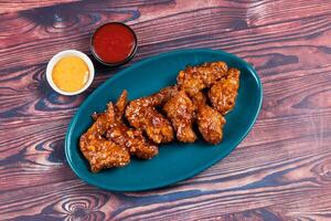 crispy chicken wings with ketchup and mayo dip served in dish isolated on background top view photo