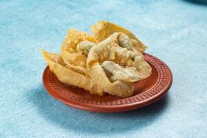 Crispy fried wonthon dim sum wraps with tomato sauce served in a dish isolaed on table top view photo