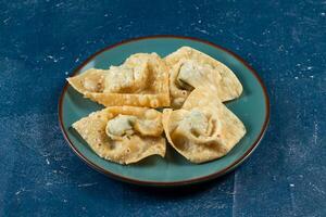 Crispy fried wonthon dim sum wraps with tomato sauce served in a dish isolaed on table top view photo