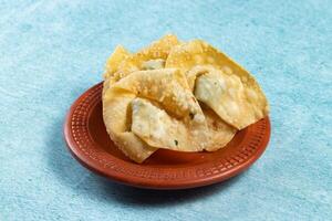 Crispy fried wonthon dim sum wraps with tomato sauce served in a dish isolaed on table top view photo