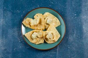 Crispy fried wonthon dim sum wraps with tomato sauce served in a dish isolaed on table top view photo