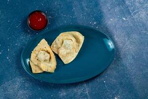 Crispy fried wonthon dim sum wraps with tomato sauce served in a dish isolaed on table top view photo